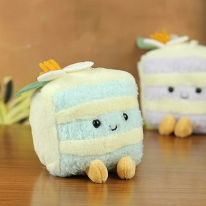Macro view of blue and yellow plush cake keychain with soft fabric and cute smile