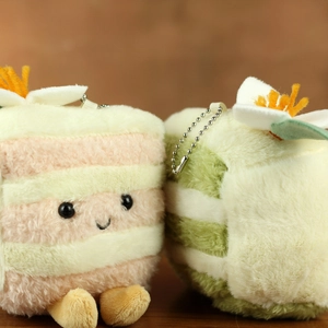 Close-up of plush cake pendants in pink and green stripes with cute embroidered faces