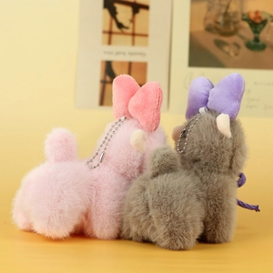 Detail of pink and gray plush alpaca pendants with cute bows and metal chains