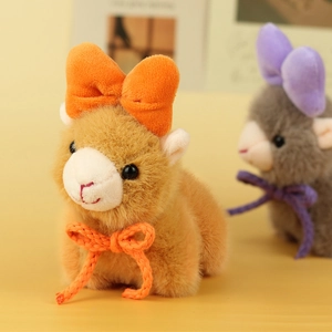 Close-up of cute plush alpaca keychain featuring soft camel fur and orange bow detail