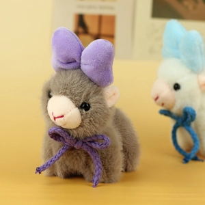 Detailed view of gray plush alpaca charm with a purple bow tie and soft fluffy texture