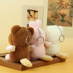Cute plush animal charms with squirrel and bear designs on a wooden tray with silver keychains