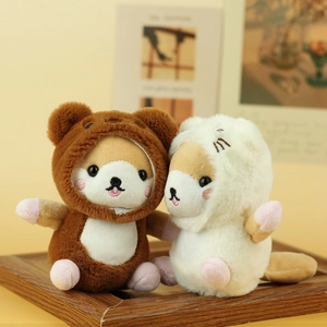 Close-up of cute plush Shiba Inu charms in bear and cat costumes on a wooden tray