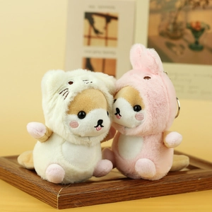 Detailed view of plush Shiba Inu keychains in pink and white animal hoodies on wood