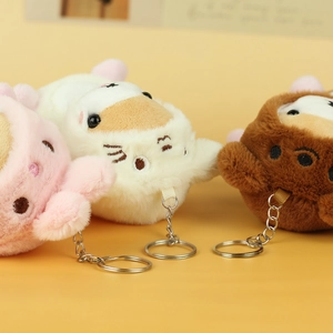 Close-up of cute plush Shiba Inu keychains in pink, white and brown with metal rings