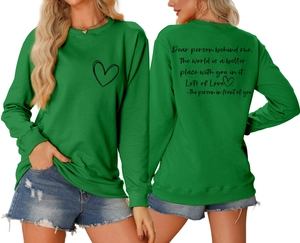 Détail d'un sweat vert avec imprimé cœur et citation sentimentale au dos du vêtement