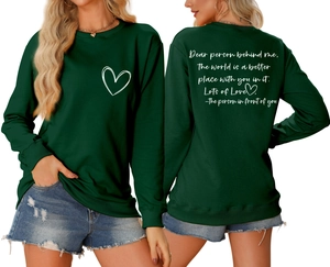 Détail du sweat-shirt vert foncé avec imprimé cœur et texte inspirant au dos