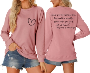 Détail du sweat à col rond rose avec imprimé cœur et texte de citation au dos
