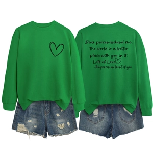 Détail du sweat-shirt vert avec imprimé cœur, texte au dos et short en jean avec trous