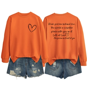 Vue à plat d'un sweat orange avec imprimé cœur et un short en jean bleu délavé