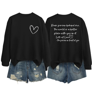 Détail du sweat-shirt en coton avec citation au dos et motif graphique de cœur blanc