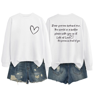 Détail à plat du sweat blanc avec imprimé cœur et texte inspirant au dos du vêtement