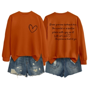 Détail du sweat orange avec texte au dos et short en jean vieilli pour femme, style décontracté