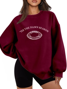 Detail of burgundy oversized sweatshirt with 'TIS THE DAMN SEASON white text and football print