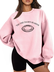Detailed close-up of pink oversized sweatshirt with Tis The Damn Season football print