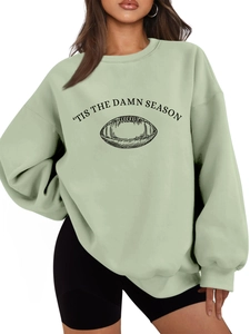 Detail of light green sweatshirt with 'tis the damn season text and football graphic