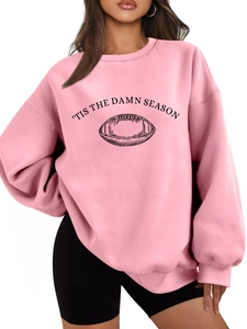 Detail of pink oversized sweatshirt featuring 'TIS THE DAMN SEASON and football print