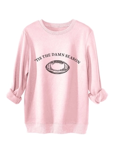 Close-up of pink crewneck sweatshirt featuring 'Tis The Damn Season' football graphic