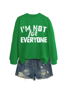 Flat lay of green sweatshirt with I'm Not For Everyone text and ripped denim shorts