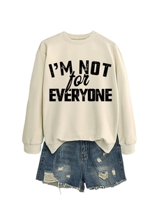 Detail of beige sweatshirt featuring 'I'M NOT for EVERYONE' print and denim shorts