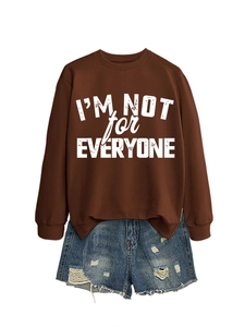 Close-up of brown sweatshirt with I'm Not For Everyone text and ripped denim shorts