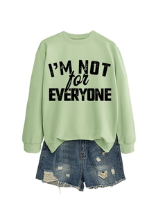 Detail of light green sweatshirt with I'M NOT FOR EVERYONE print and denim shorts