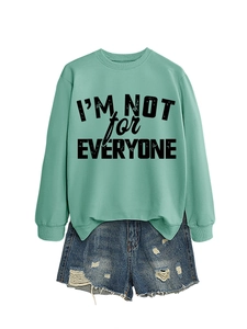 Flat lay of mint green sweatshirt with slogan and distressed blue denim shorts