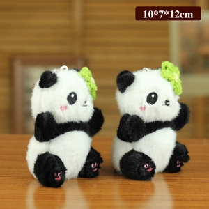 Porte-clés panda en peluche avec petite fleur verte sur table en bois 10x7x12cm