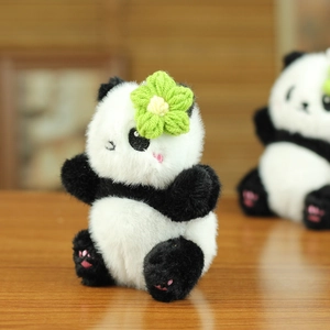 Détail de porte-clés peluche panda avec fleur en crochet et broderie douce de pattes