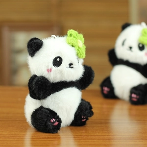 Détail d'un porte-clés panda en peluche avec fleur verte et texture douce et soyeuse