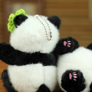 Détail du porte-clés panda en peluche avec fourrure douce et nœud vert tressé