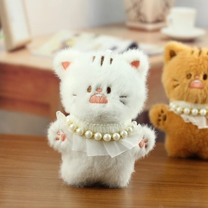 Detail van schattige kattenknuffel met parelkanten halsband en roze borduurwerk