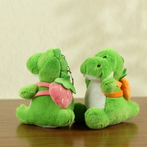 Close-up of cute plush dinosaur pendants with strawberry and carrot backpacks