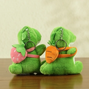 Detail view of plush dinosaur keychains featuring strawberry and carrot backpacks