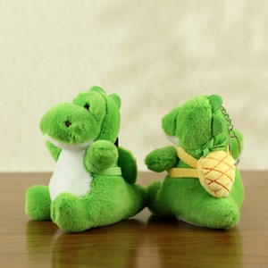 Macro shot of cute green dinosaur plushies with yellow pineapple backpacks and keychains