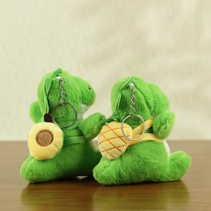 Detail of plush dinosaur keychains with sunflower and pineapple bag accessories