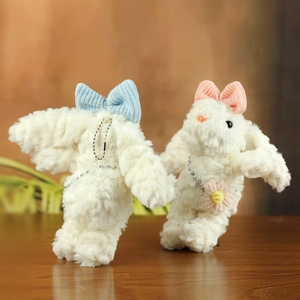 Dettaglio di ciondoli a forma di coniglio in peluche con fiocchi blu e rosa e catenine