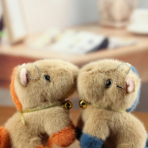 Detailed macro view of plush pony keychains with soft brown fur and golden bells