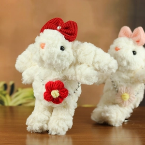 Dettaglio di due portachiavi a forma di coniglio in peluche fatti a mano con fiocchi