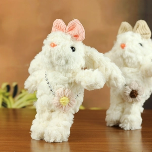 Dettaglio portachiavi a forma di coniglio in peluche con fiocco e fiore in morbido pelo