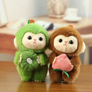 Porte-clés singe en peluche avec kiwi et pêche sur un bureau en bois naturel