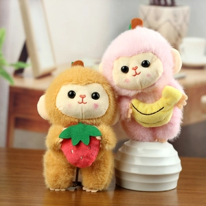 Gros plan de charmants porte-clés singes en peluche avec accessoires fraise et banane
