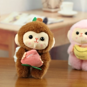 Gros plan d'un porte-clés singe en peluche marron tenant une pêche rose douce