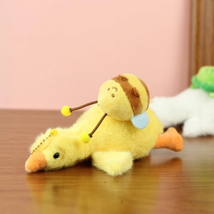 Gros plan sur un canard en peluche avec abeille et chaîne à billes dorée