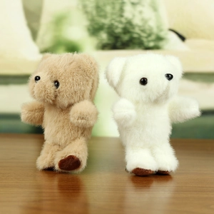 Süße Teddybär-Plüschanhänger in Braun und Weiß auf einer Holzoberfläche