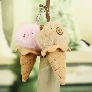 Cute capybara ice cream plush keychains in pink and brown with metal chains hanging on a branch