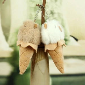 Detail of plush ice cream capybara keychains in light brown and cream colors