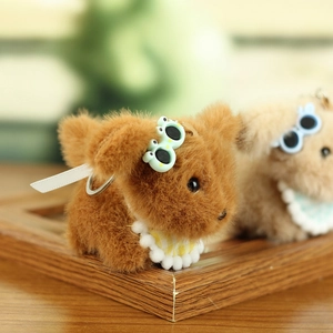 Close-up of cute plush dog keychain with frog sunglasses and plaid scarf detail