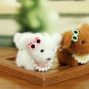 Close-up of cute plush teddy puppies with sunglasses and plaid bibs as keychains