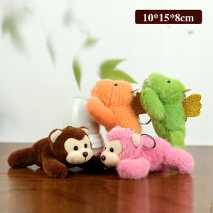 Set of four cute plush animal keychains in various colors on a wooden table